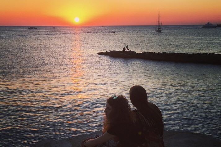 Pareja en actitud romántica mirando atardecer en Sant Antoni, Ibiza