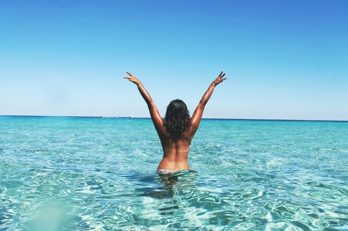 Mujer en la playa tras organizar sus vacaciones